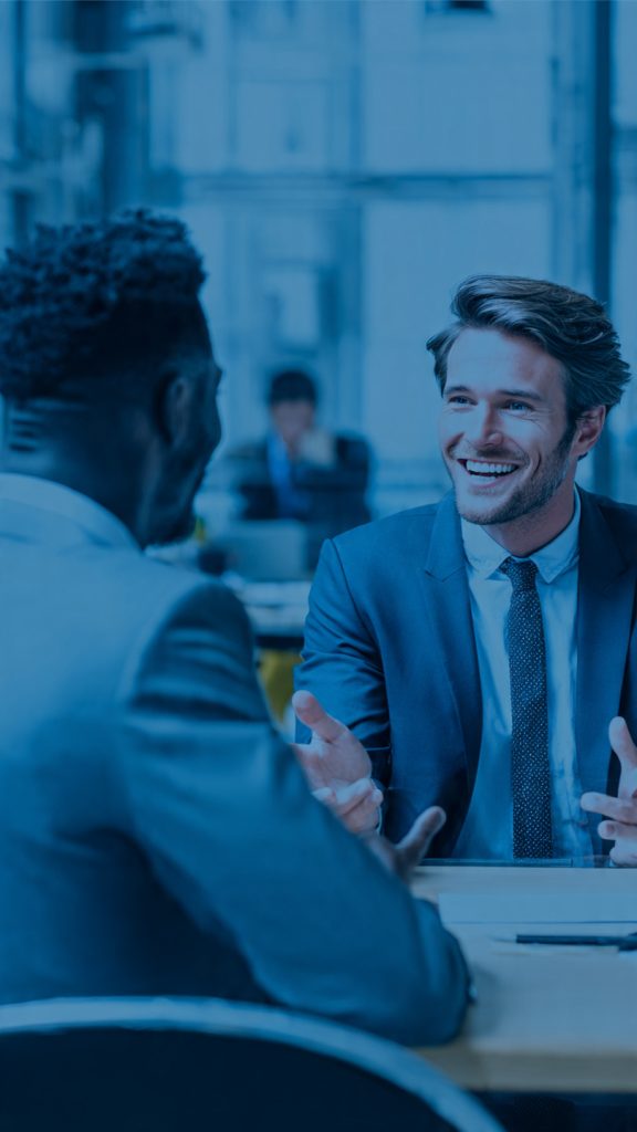 Network
A professional networking-themed banner showing two business professionals engaged in a friendly conversation across a table in a modern office setting. One person is speaking while gesturing confidently, and the other is listening attentively. The bright workspace, corporate attire, and collaborative atmosphere represent professional relationship-building, career growth, and networking with experienced professionals. The design conveys success, mentorship, and meaningful business connecti